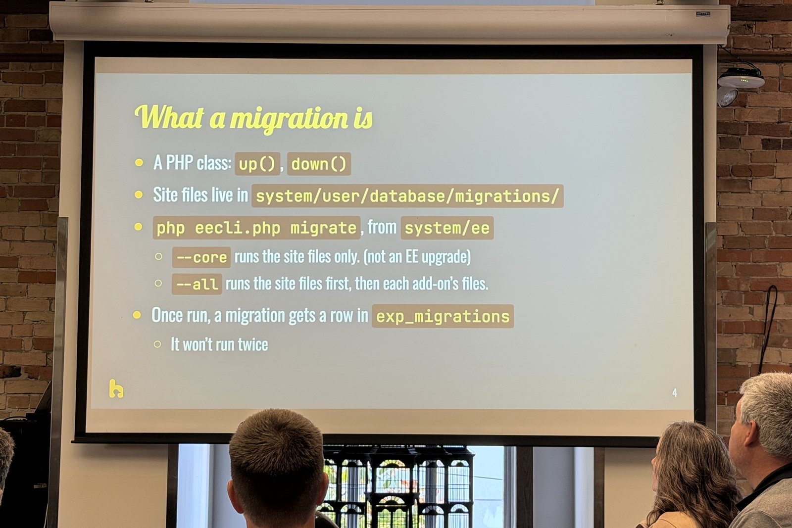 Slide titled What a migration is, explaining ExpressionEngine migration files